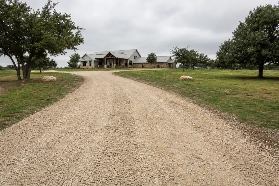 Freshly graded crushed stone driveway leading up to a house