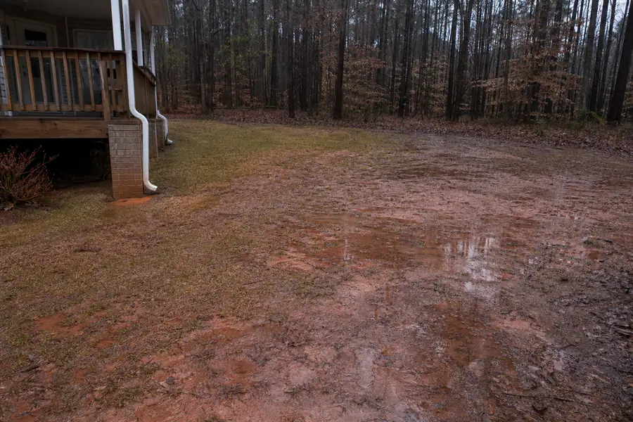 Backyard in North Carolina with standing water on a red clay lawn after a storm