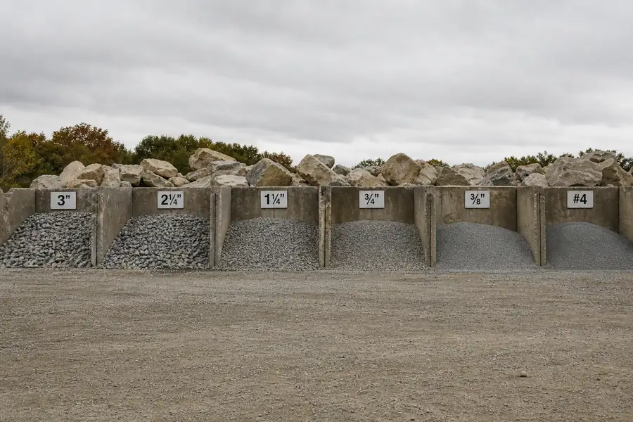 Gravel yard with labeled bins of crushed stone sizes