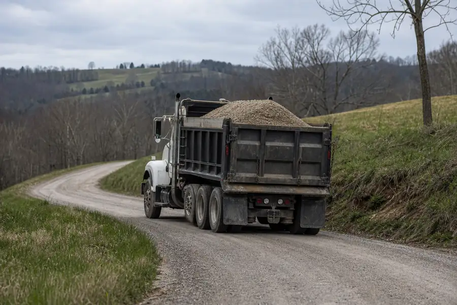 Gravel delivery truck on a rural road with rolling Piedmont hills